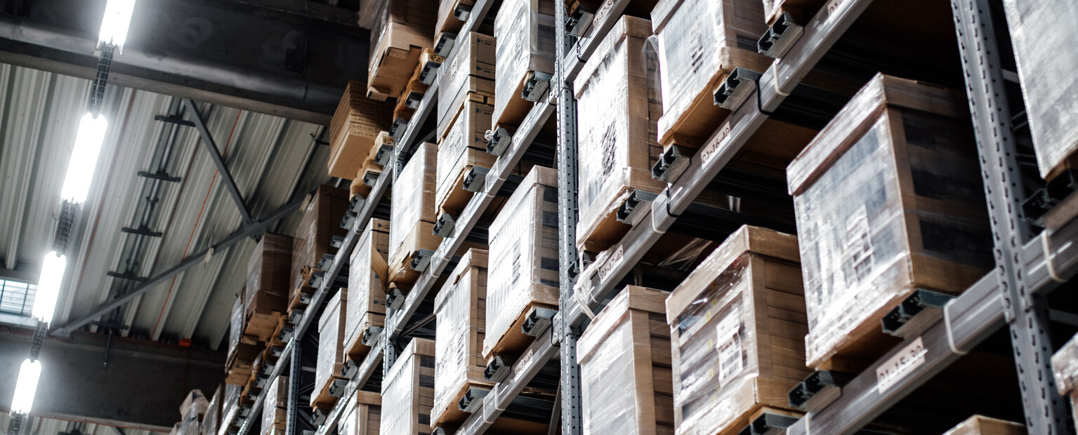 Des palettes de marchandises rangées sur les rayonnages d’un entrepôt.